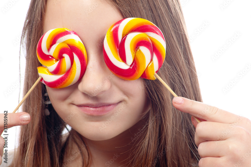 Beautiful teenage girl hiding her eyes with lollipops