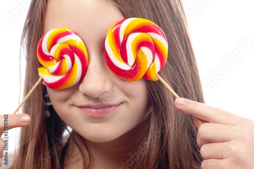 Beautiful teenage girl hiding her eyes with lollipops