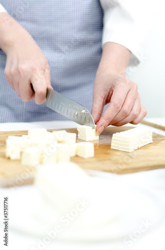 Woman's hands cutting feta cheese