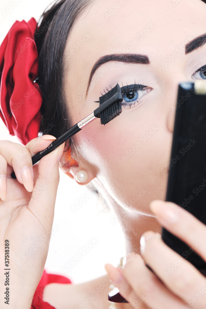 beautiful young woman applying makeup - obrazy, fototapety, plakaty 
