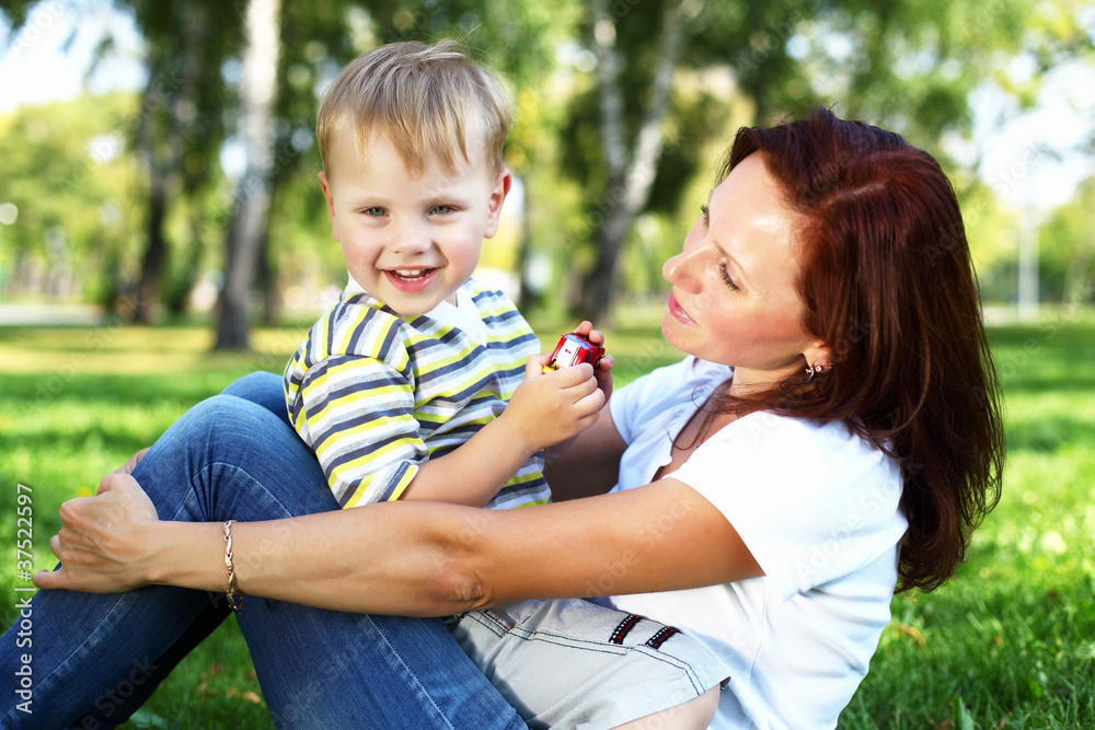 Young mother with her son in summer park