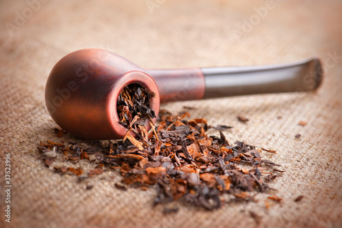 Smoking pipe and tobacco on linen canvas background photo