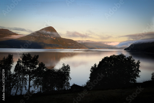 Inverse cloud in the Norwegian mountains by lake.