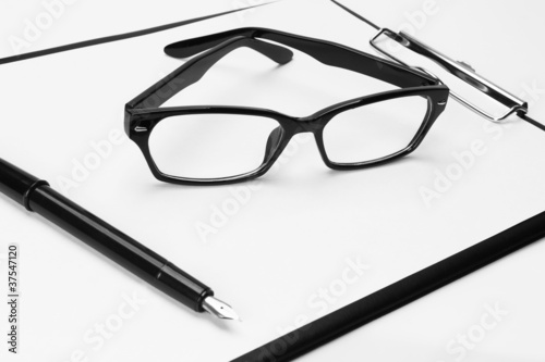Blank clipboard with pen and eyeglasses