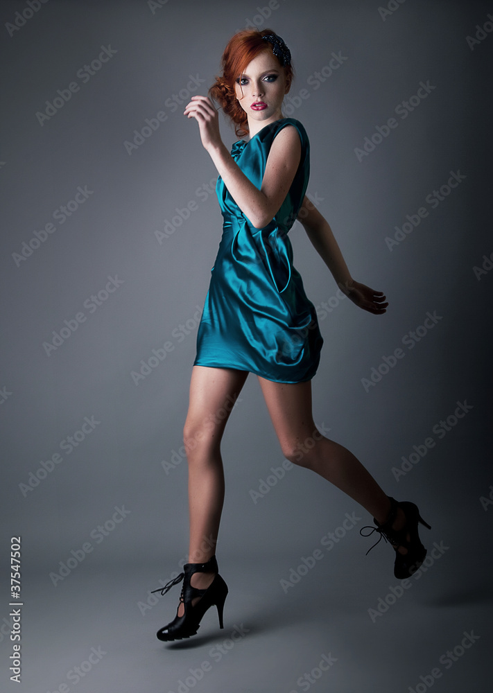 Healthy young active redhead girl running in blue dress Healthy young active redhead girl running in blue dress