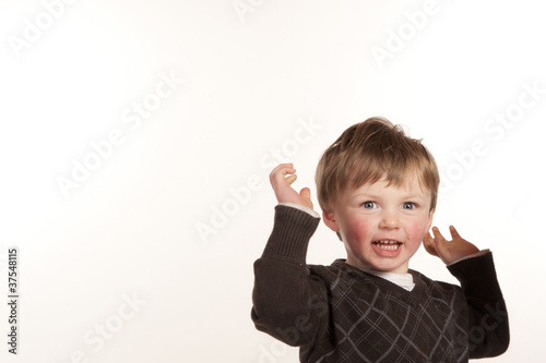 happy cute little boy throwing arms in air