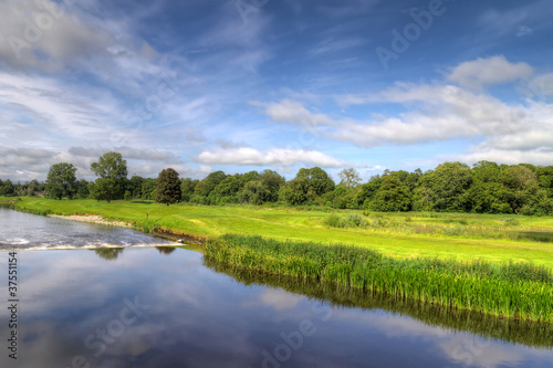 Idyllic golf course with reflection in the river