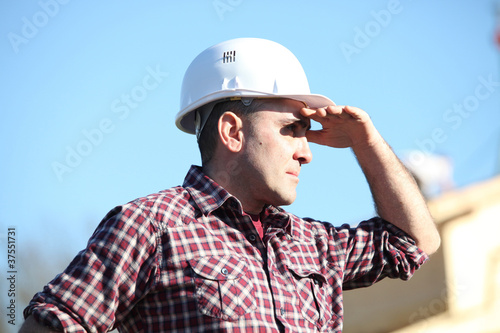 Tradesman shielding his eyes from the sunlight