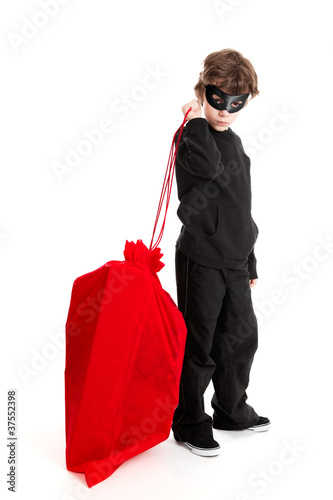 Canvas Print Child stealing Santa's sack isolated on white