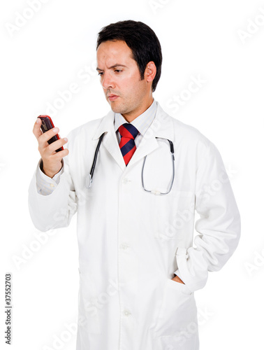Young doctor reading a message on the phone and looking worried
