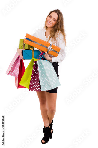 Elegant smiling woman carrying shopping bags and gifts on white