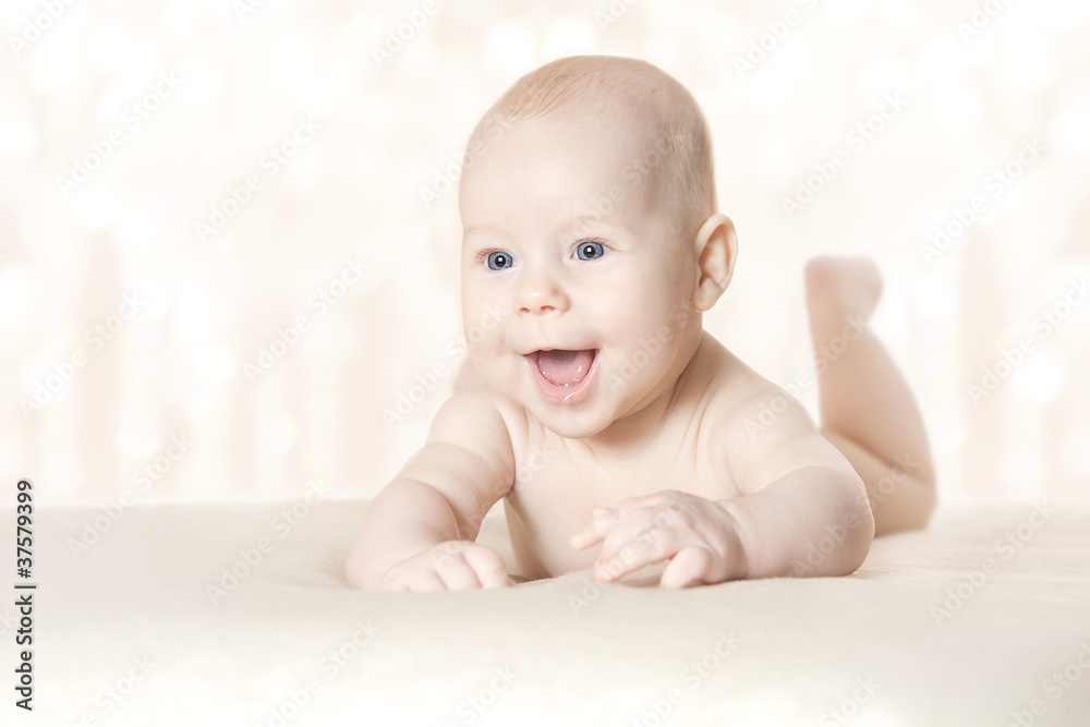 Happy active baby lying on stomach over blanket Happy active baby lying on stomach over blanket