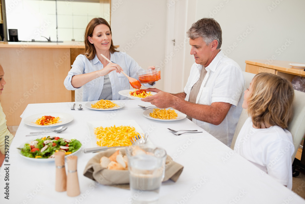 Woman serving dinner to family