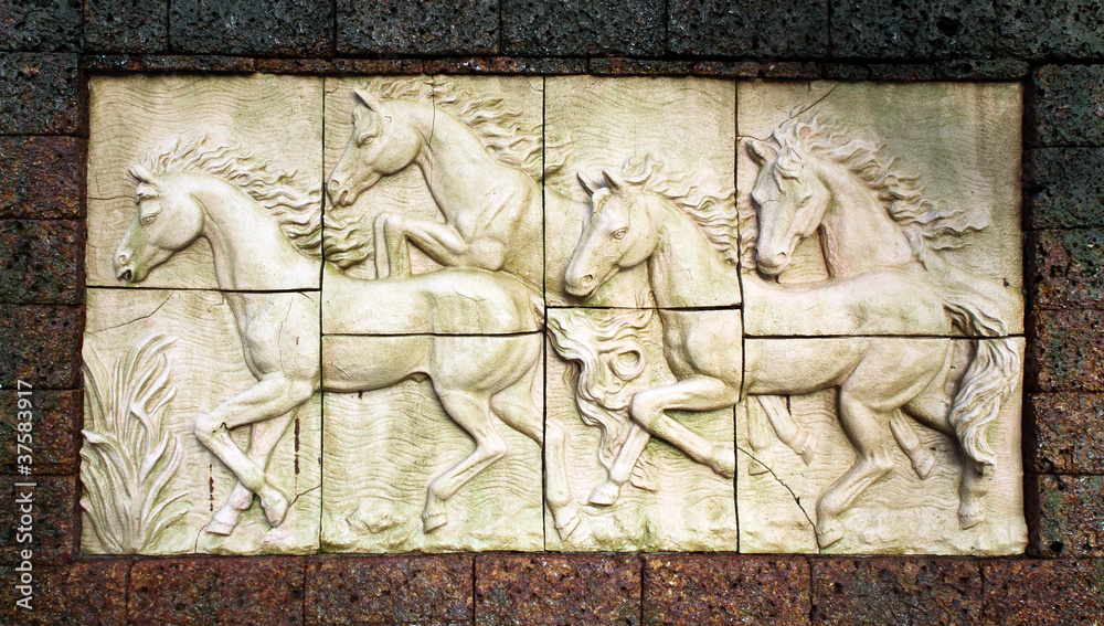 Stone sculpture of horse on wall