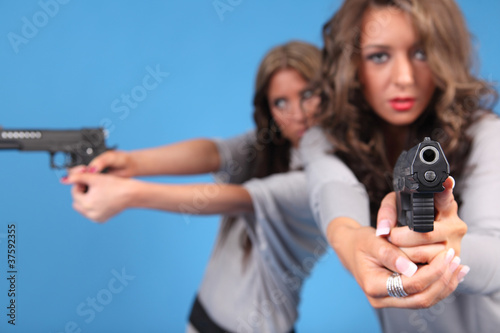 Two beautiful women with pistols.