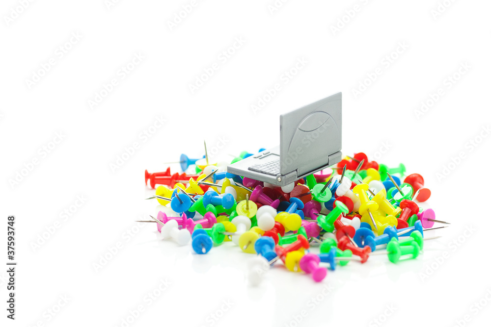 miniature laptop and colored pins isolated on white