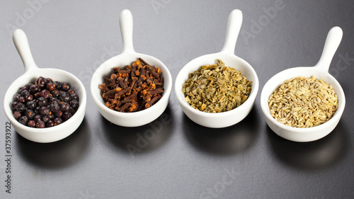 Row of assorted spices in white bowls