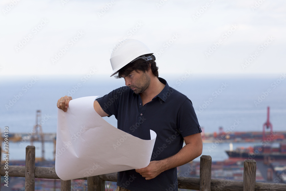 Ingenieur mit Zeichnung in der Hand vorm Hafen