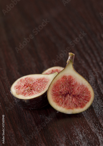 Black mission figs on dark wood background.