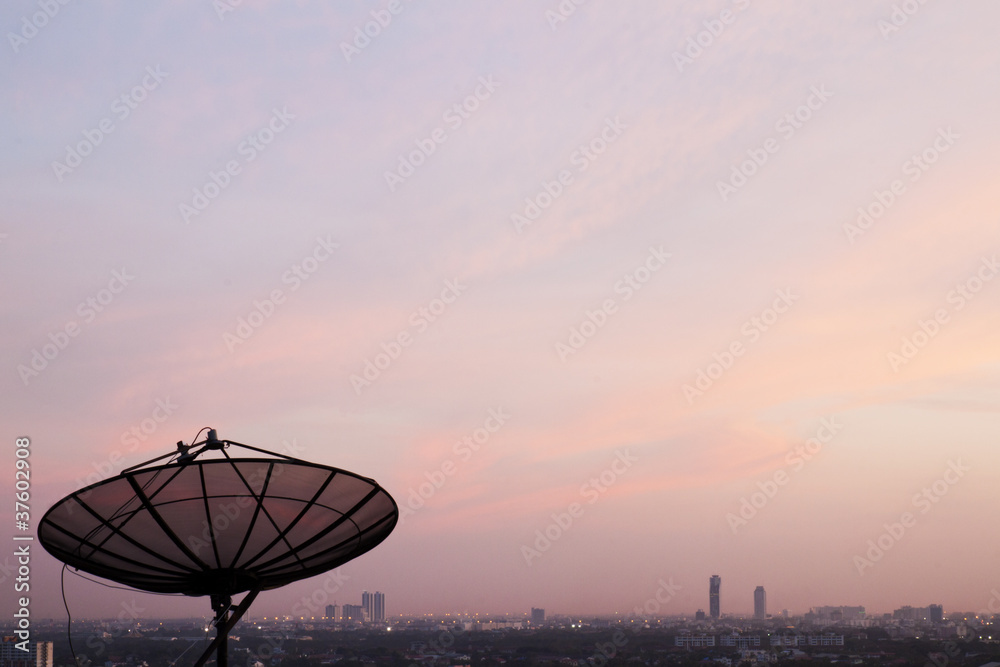 Satellite dish on building in sunset background