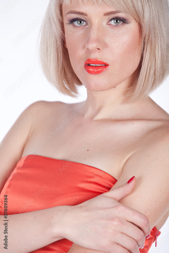 Obraz premium Portrait of a beautiful young woman in red dress. Isolated over
