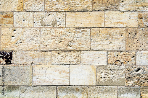 Fragment of a stone wall made of limestone bricks