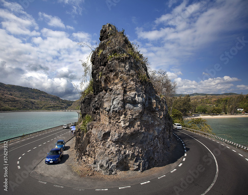 Kind on abrupt turn of road and a rock at coast