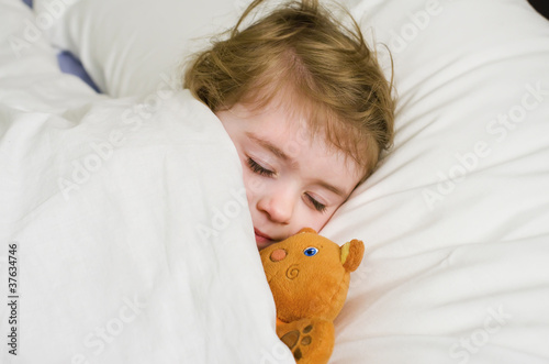 Bambina che dorme con orsetto photo