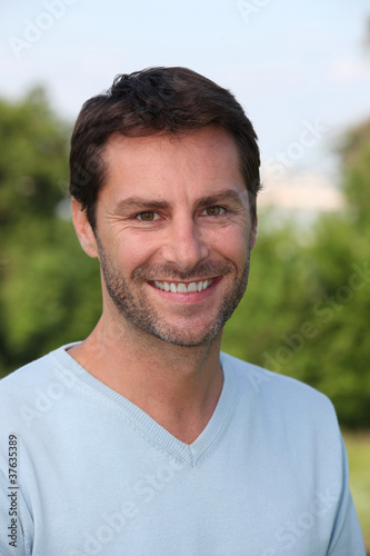 A portrait of a male model in a park.