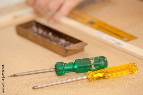 Foto screwdriver on a wood workbench in front of a burin