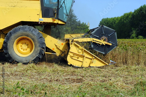 close up of a yellow combine harvester in a soy field