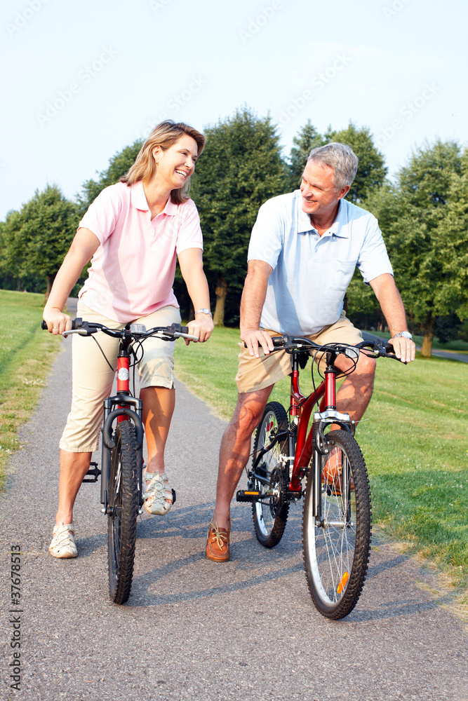 Obraz premium Senior couple cycling in park.