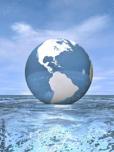 Globus schwimmt auf bewegter Wasseroberfläche unter blauem Himme