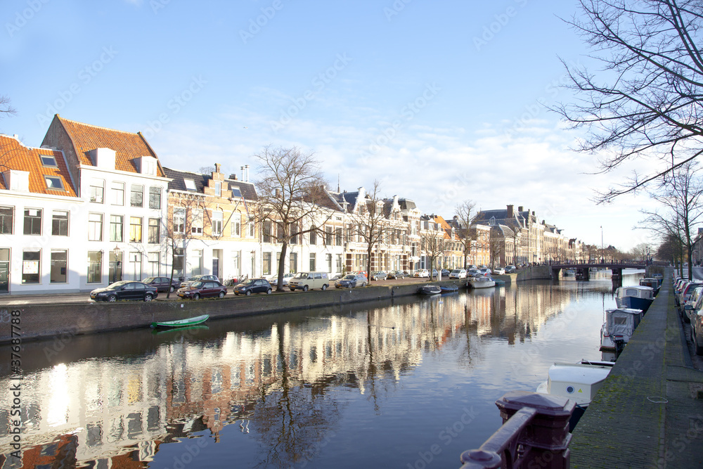 Dutch canal with old houses and boats with blue sky