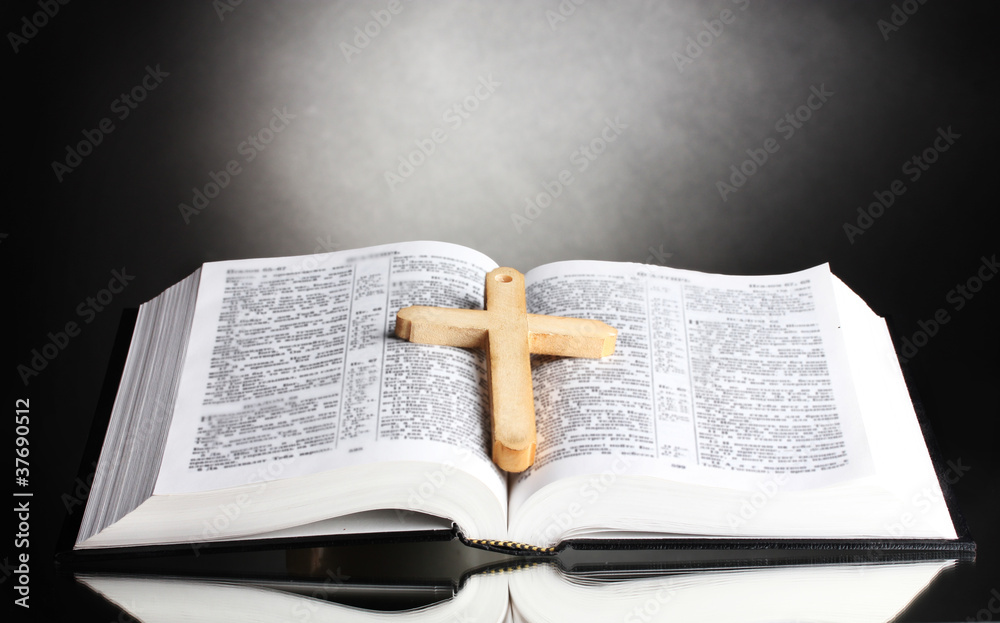 Fototapeta premium Russian open holy bible with wooden cross on black backround
