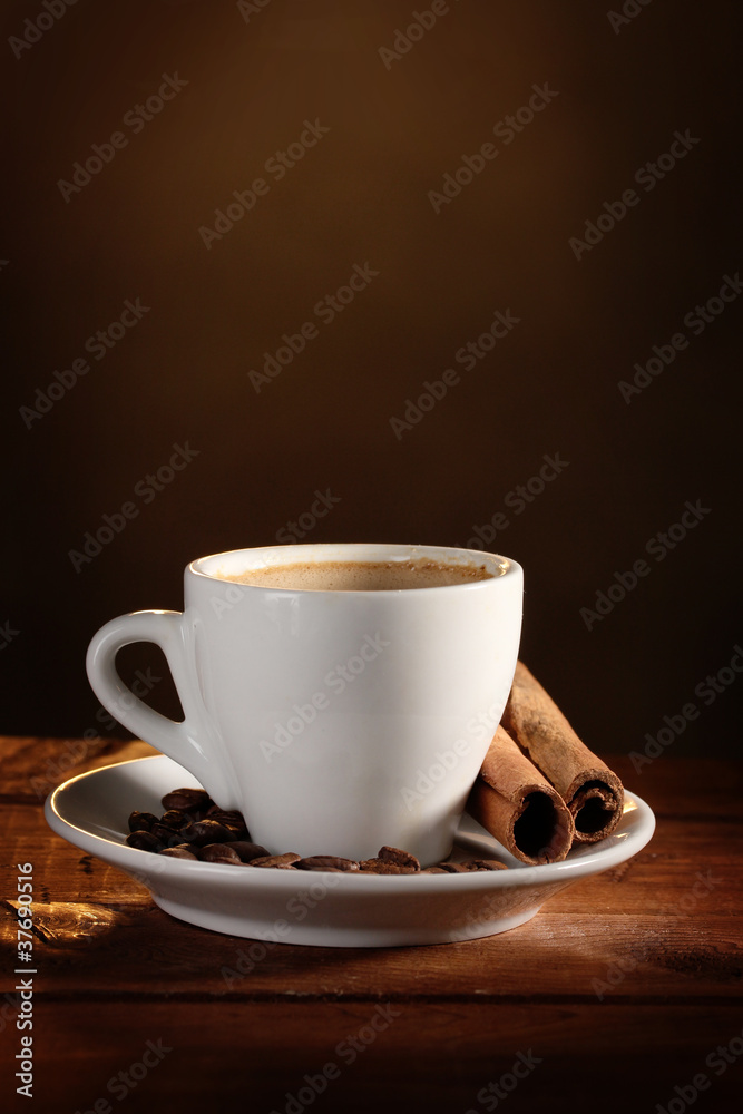 cup with coffee, cinnamon and coffee beans