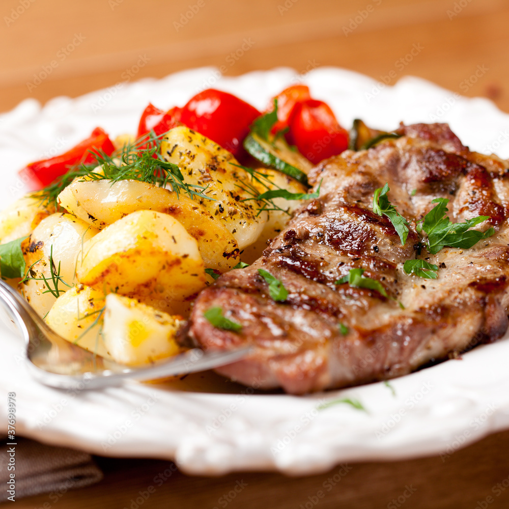 Grilled pork steak with roasted potatoes and herbs Grilled pork steak with roasted potatoes and herbs