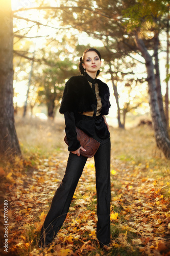 portrait of the young business woman in autumn park