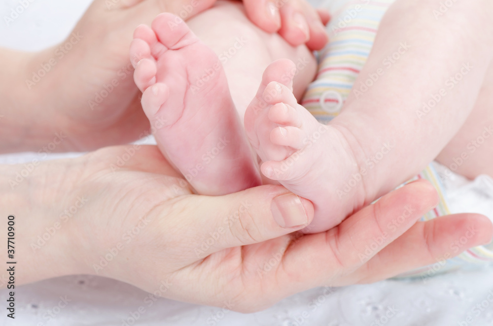 Mother's hands holding baby's feet Mother's hands holding baby's feet