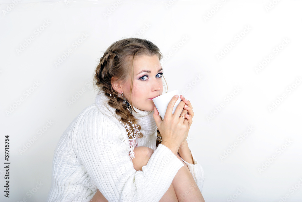 The young beautiful girl in a white scarf with a mug The young beautiful girl in a white scarf with a mug