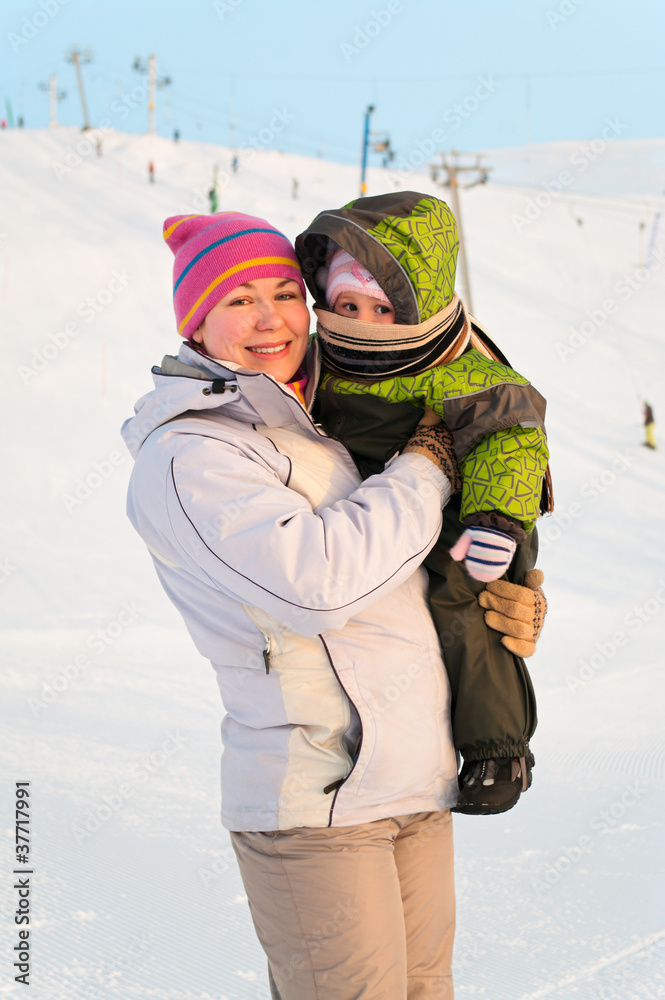 Mother and her little child standing on winter ski mountain Mother and her little child standing on winter ski mountain