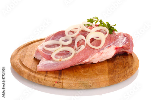 Raw meat and onion on a wooden board isolated on white