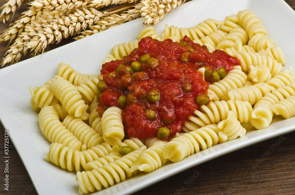 Italian pasta with sauce of tomatoes and fresh green peas Italian pasta with sauce of tomatoes and fresh green peas