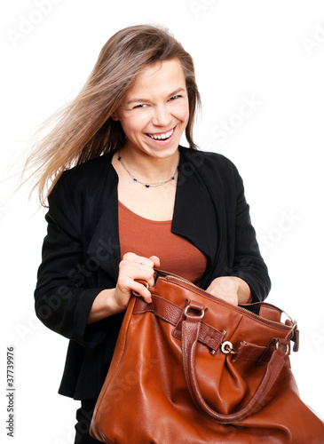 Young smiling woman seeking in big brown handbag
