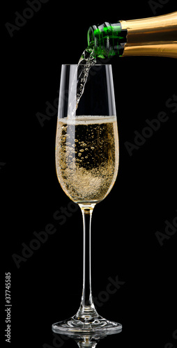 Champagne pouring into a glass on a black background