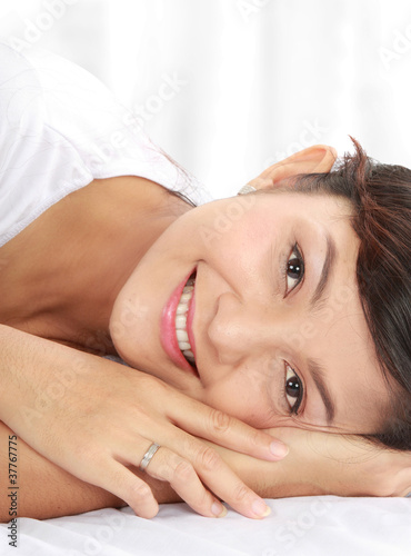 woman smiling while lying down on bed