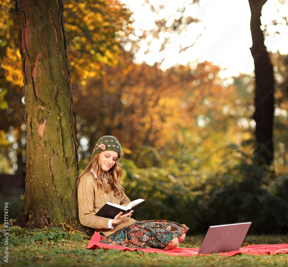 Young woman reading a book in the city park Young woman reading a book in the city park