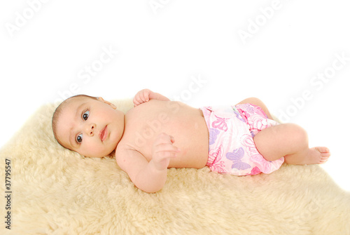 A beautiful  baby laying on a fur rug