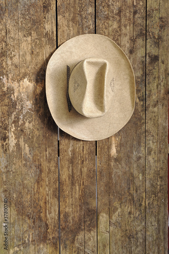 cowboy hat hangin on an old wooden wall