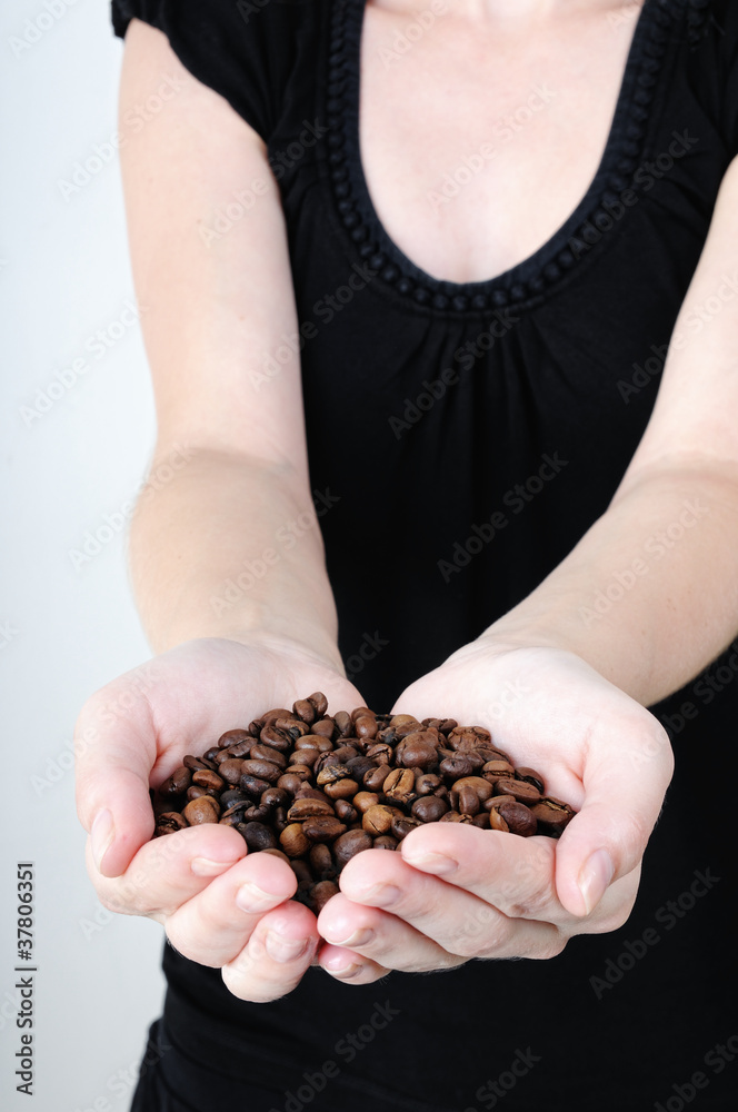 Woman holding hands in coffee beans Woman holding hands in coffee beans